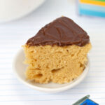 Microwave Caramel Cake slice on plate topped with chocolate frosting